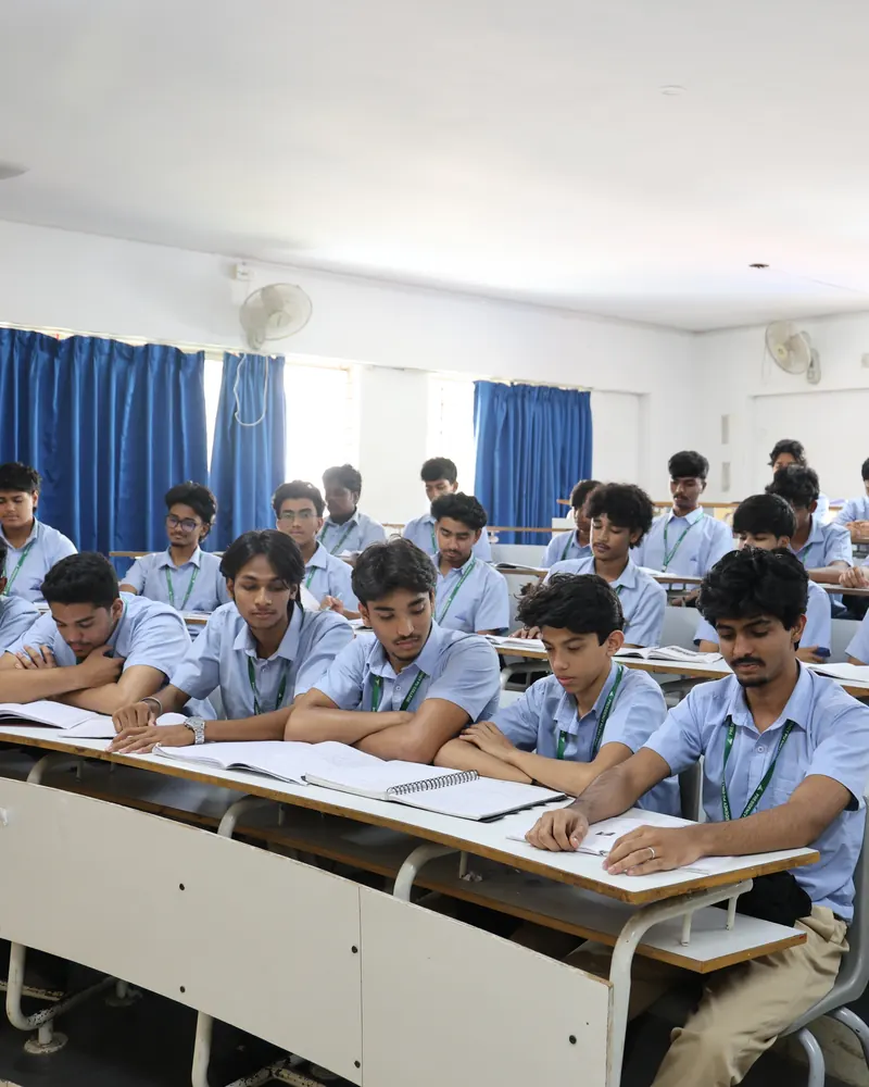 A Presidency PU classroom full of students in uniform, seated at curved desks with their notebooks open.